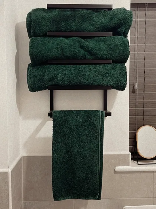 Black Wall-Mounted Rack with Green Towels