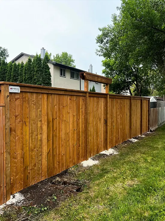 Board-on-board cedar fence with stain and a tall cap rail