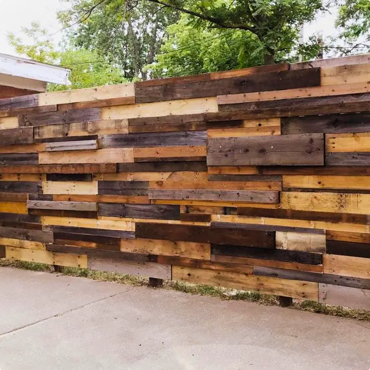 Horizontal patchwork privacy fence made from reclaimed pallets