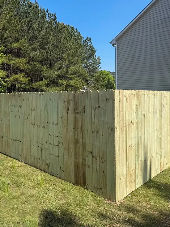 Solid dog-ear privacy fence in fresh pale green-gray wood