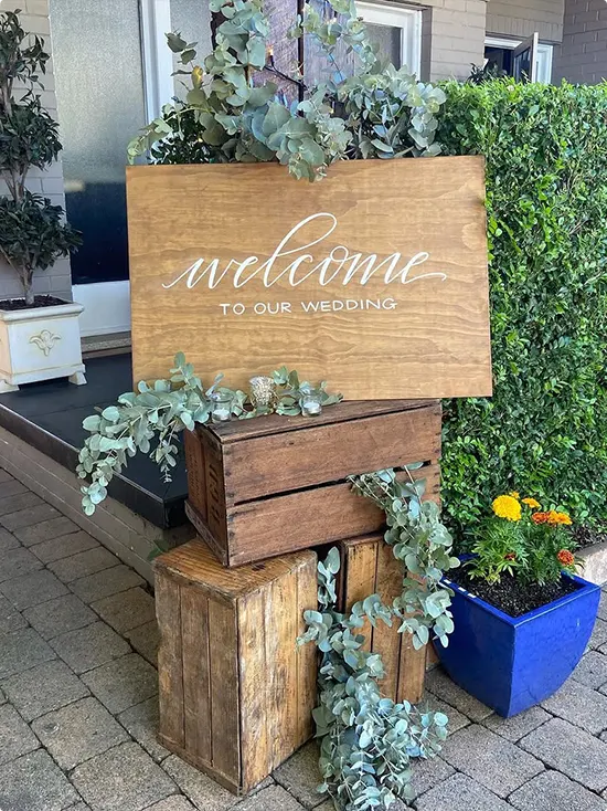 Stained Wood Welcome to Our Wedding Sign on Stacked Crates