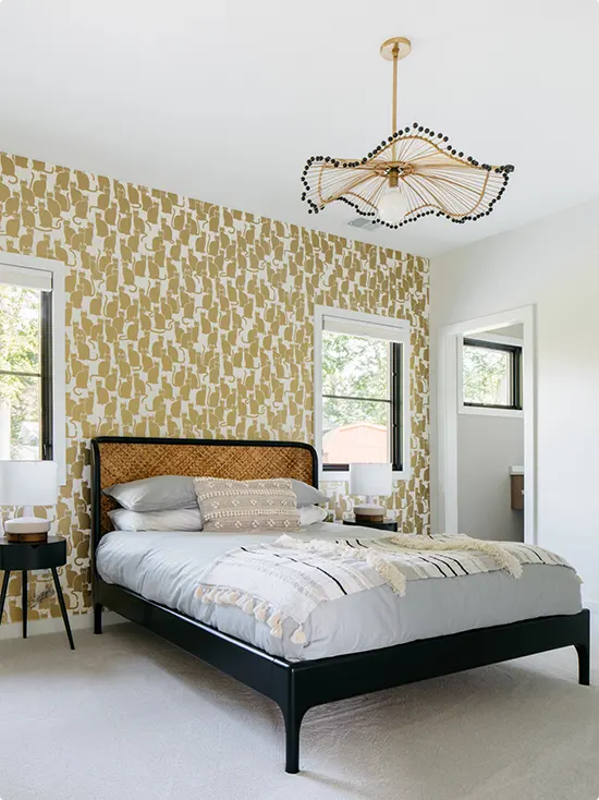 Golden cat print wallpaper, black bed frame, light gray bedding, rattan chandelier