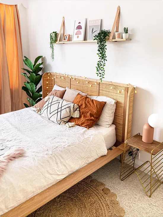 Shelf with leather straps above a rattan headboard