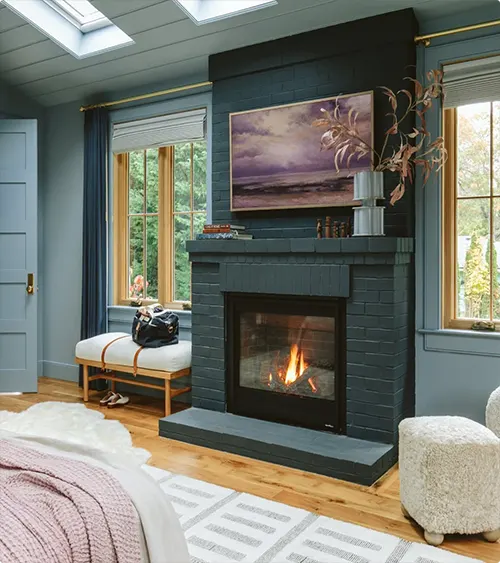 A shiplap wall in dark teal with a black fireplace