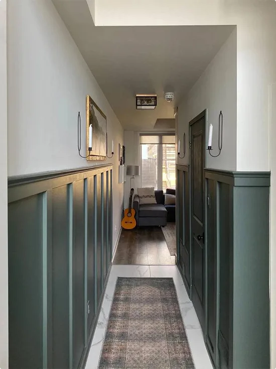 Dark Teal Board-and-Batten Hallway with Black Sconces