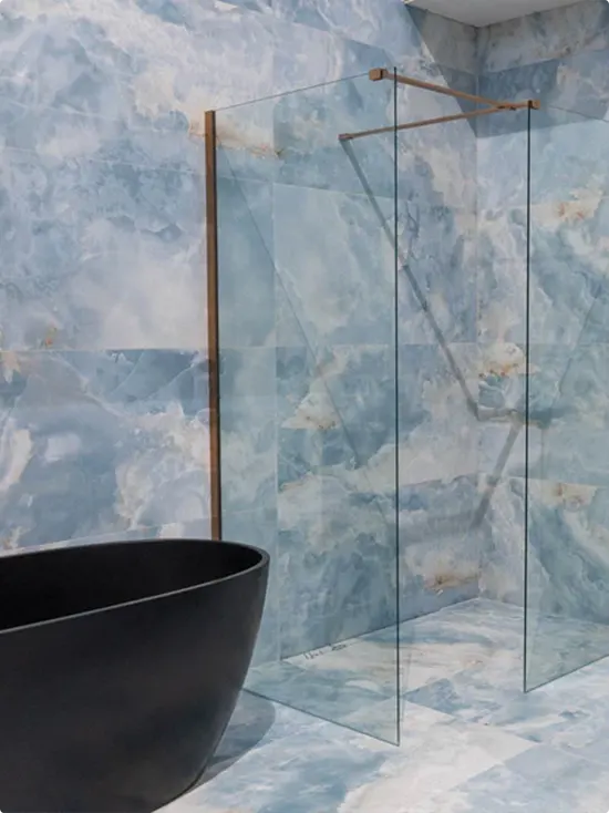 Matte Black Freestanding Bathtub Along Blue Marble Walls