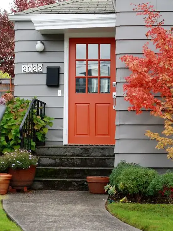 Gray Craftsman home with an orange front door