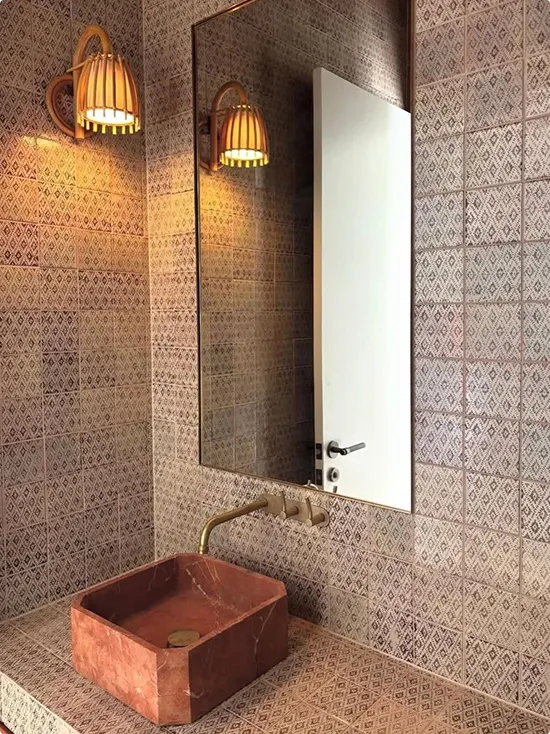 Rattan sconces and patterned brown bathroom tile