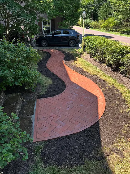 Red S-Curve Brick Path in a Mulched Front Yard