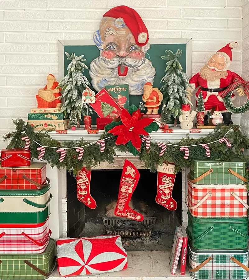 Stacked tins and vintage Santa art on a kitsch Christmas mantel