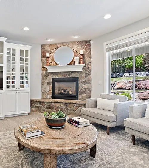Irregular Stone Fireplace Surround with Oversized Round Mirror