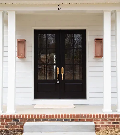 Black double doors with full glass and copper sconces