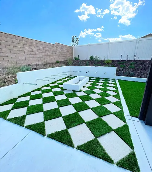 Checkerboard Paver and Artificial Grass Patio with White Concrete Fire Pit