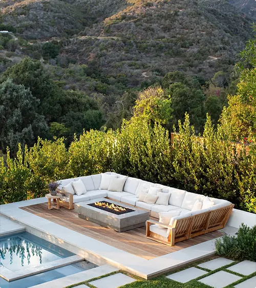Fire pit area beside the pool with built-in seats