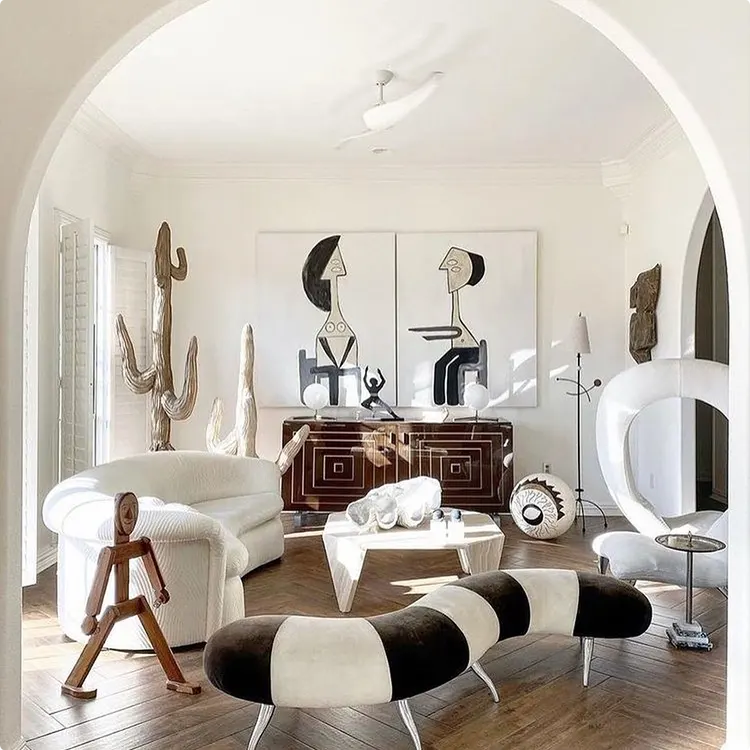 Black and white living room with sculptural details and an arched entry