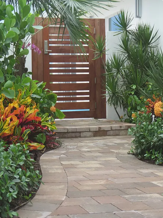 Curved Clay-Toned Paver Walkway and Wood Gate