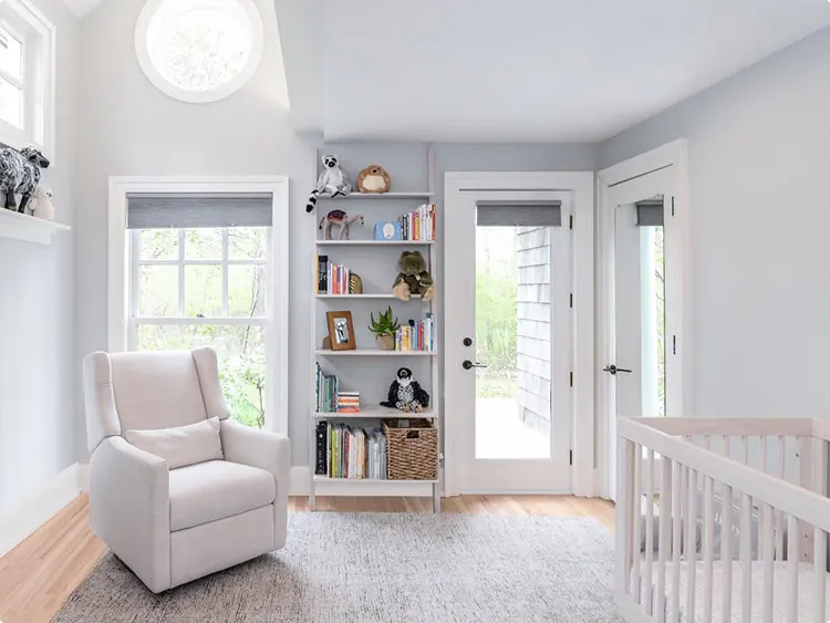 A nursery corner with natural light and built-in shelves