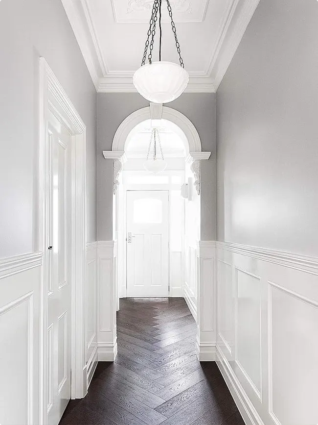 Architectural Arched Doorway with Dark Gray Herringbone Floor and White Wainscoting