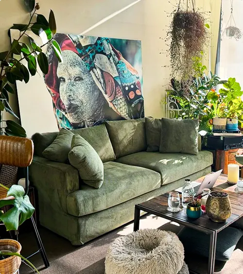 Green Couch with Colorful Art and Hanging Plants