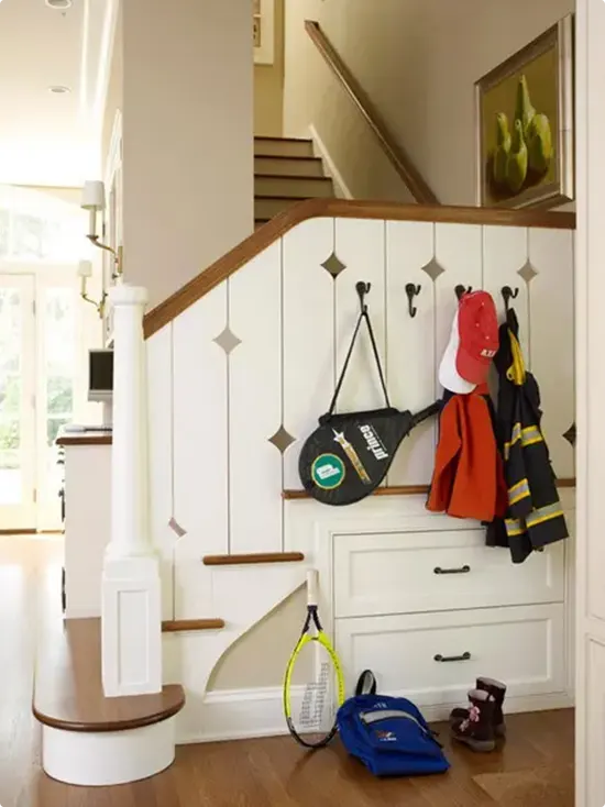 Below-Staircase Paneled Cabinetry with Hooks and Drawers