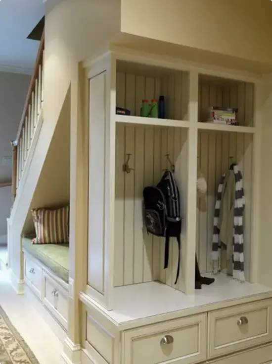 Mudroom cubbies beneath the staircase with drawers