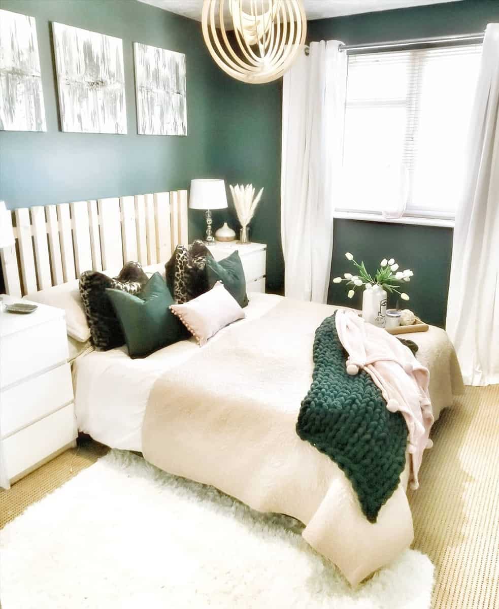 accent-wall-green-bedroom-ideas-elizabethjane_decor Cozy bedroom with green walls, modern decor, white bedding, green accents, and a large wooden pendant light
