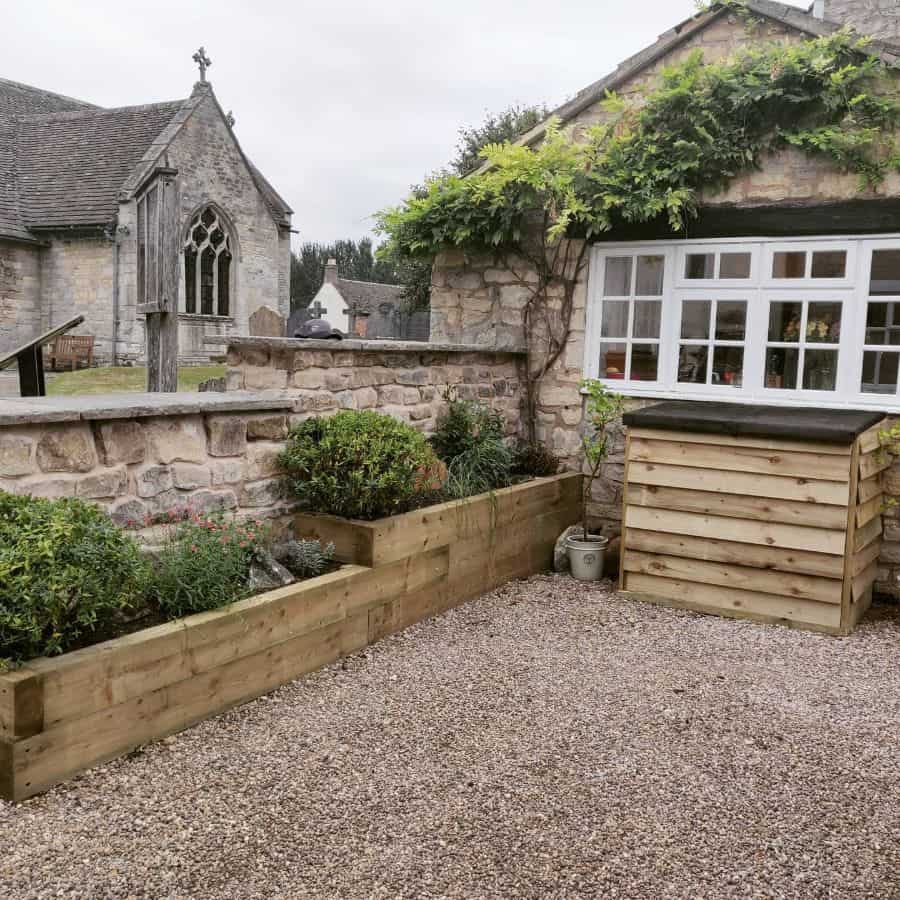 gravel backyard with wood retaining wall garden
