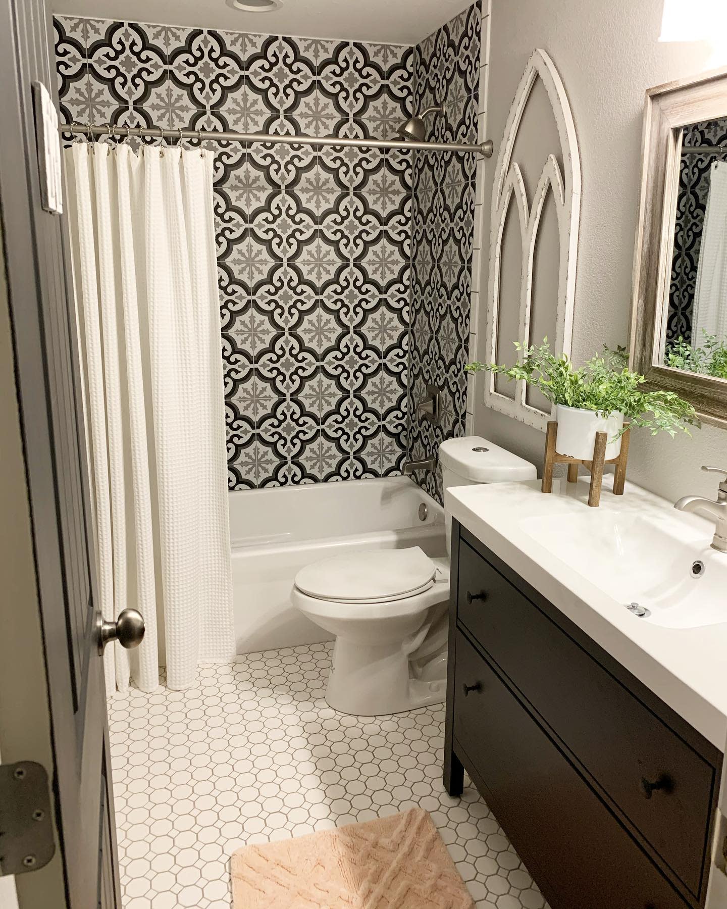 bathroom20basement20apartment20ideas20-painterplacehomeco Elegant bathroom with black-and-white patterned wall tiles, hexagonal floor tiles, and modern vanity.