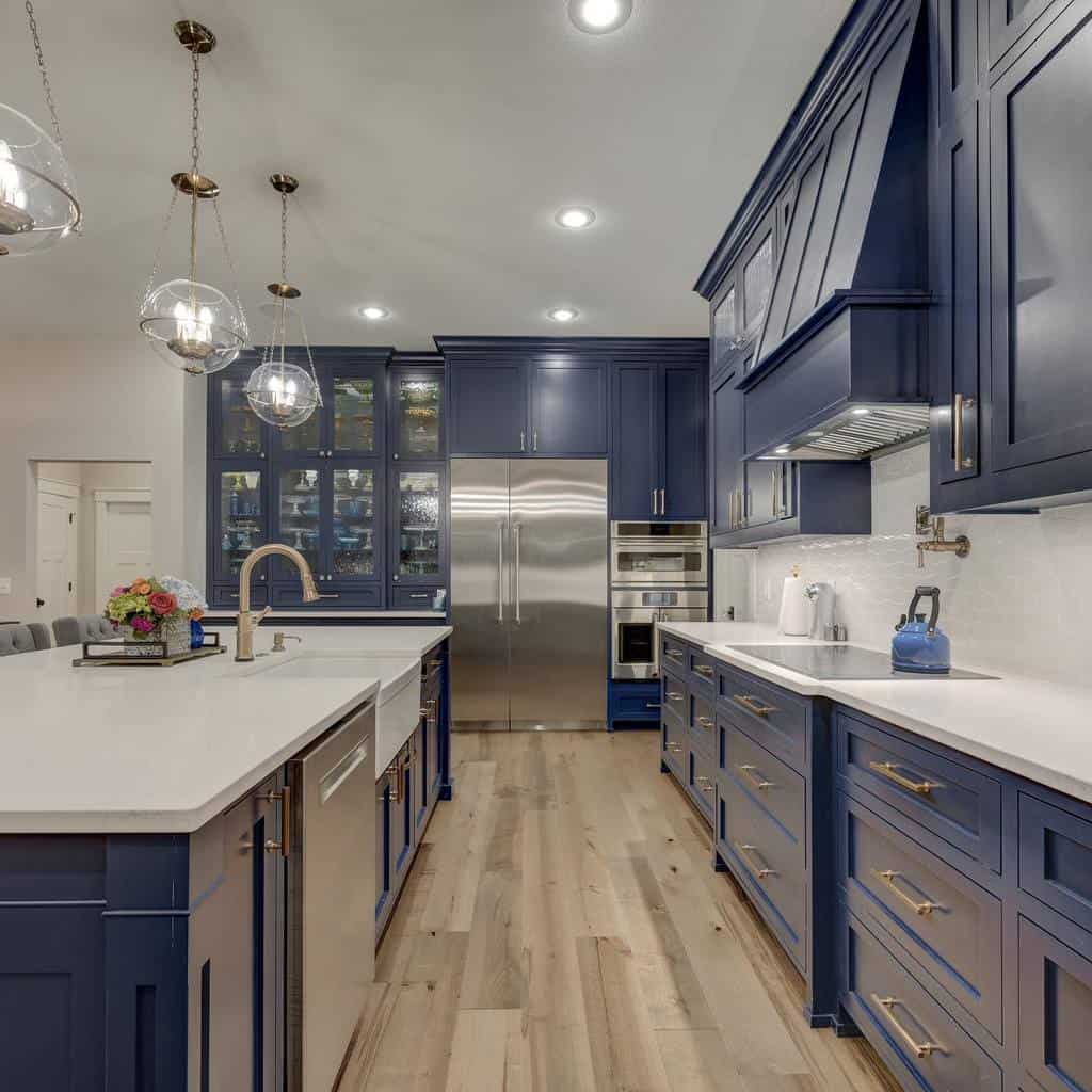blue cabinets with gold accents in country kitchen white granite countertops