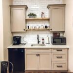white tile backsplash cream cabinet kitchen black fridge
