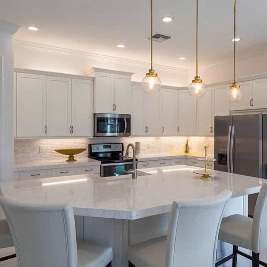 large white cabinet kitchen with curved island and pendant ceiling lights