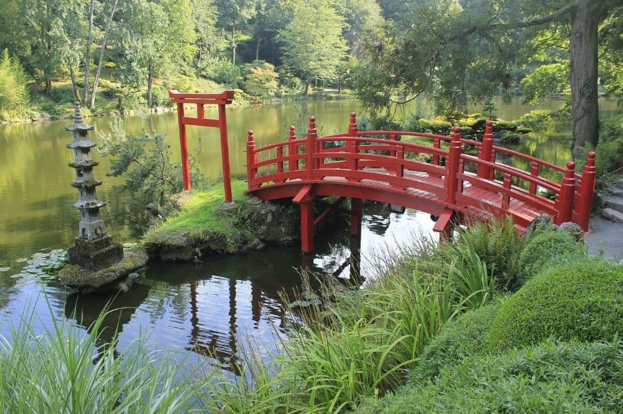decor-and-religious-sculpture-zen-garden-ideas-2 wood red bridge leading to stone temple statue