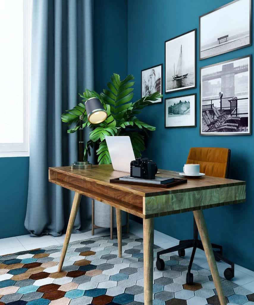 blue home office with wood desk and framed wall images