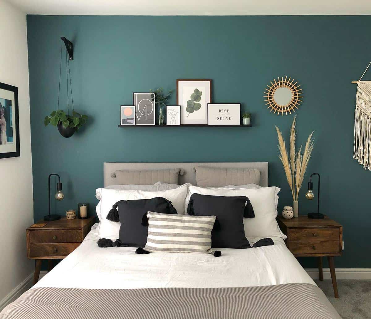 forest-green-bedroom-ideas-our_leyburn_home Modern bedroom with teal accent wall, gray bedding, wooden nightstands, and wall-mounted decorations