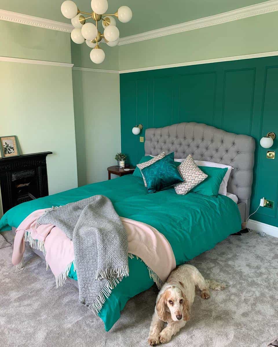 guestroom-green-bedroom-ideas-restoring_ingleside A cozy bedroom with a teal theme, a tufted headboard, and a dog lying on the carpet beside the bed