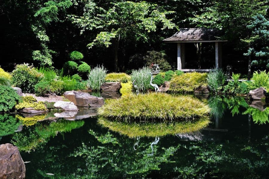 koi-pond-zen-garden-ideas-1 large garden with pond and small island with bird statues