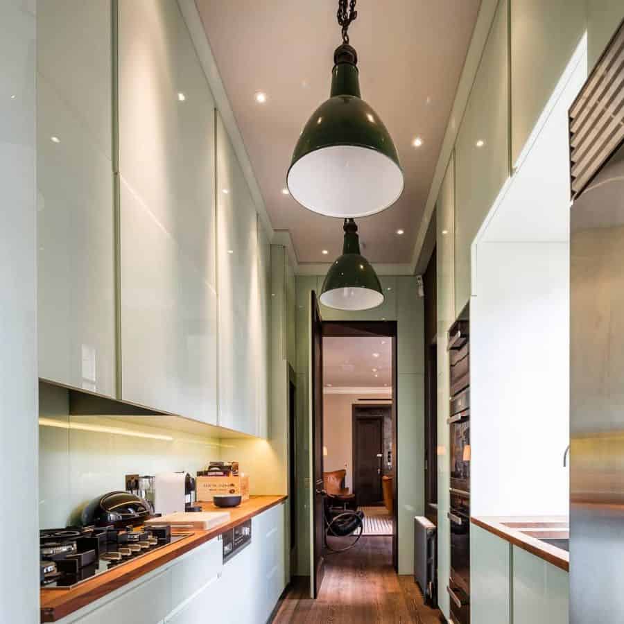 narrow gallery kitchen with green cabinets