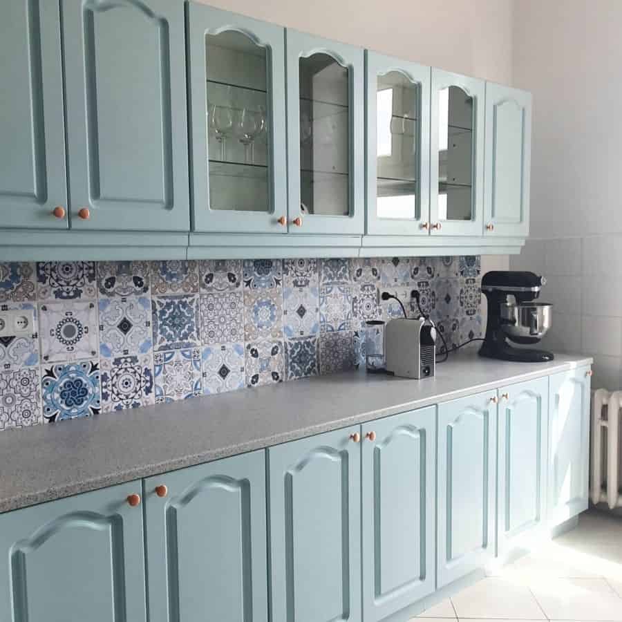mint green kitchen cabinets with pattern tile splashback