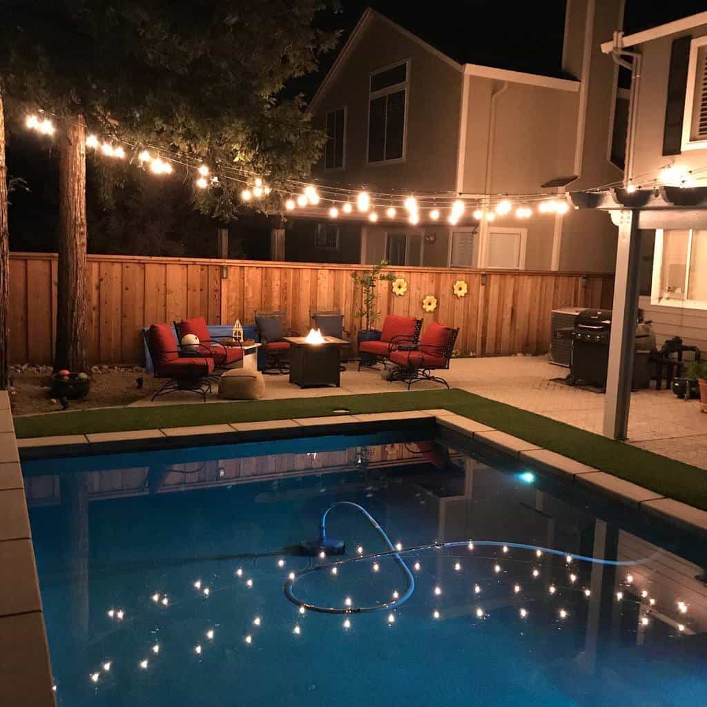 pool-patio-lighting-ideas-larcomslighting string lights over backyard pool and patio with fire pit