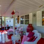 enclosed patio painted red floor white wicker furniture