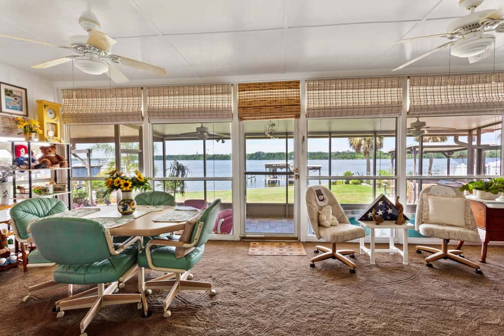 rustic-enclosed-patio-ideas-1 rustic enclosed patio tile floor river view table and chairs ceiling fans