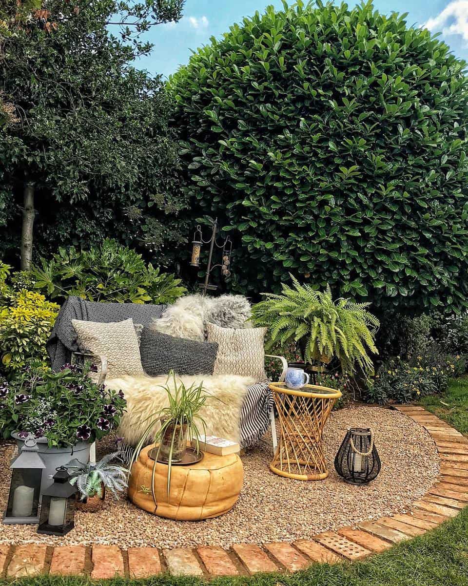 rustic-garden-bench-ideas-deb_at_no_70 garden bench with throw rug and pillows pot plants wicker table