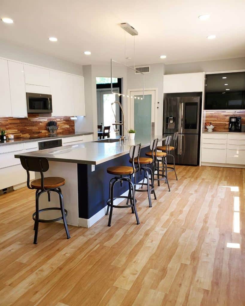large kitchen with white cabinets with seating around island