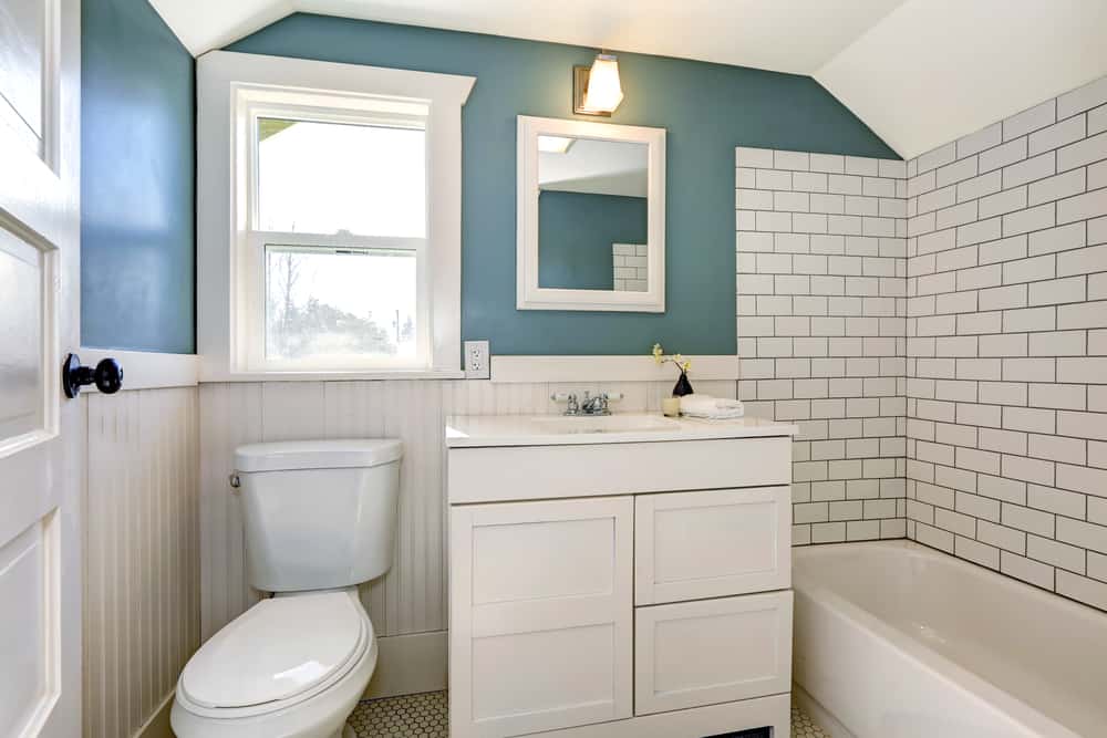 white tile bathroom with green accent walls