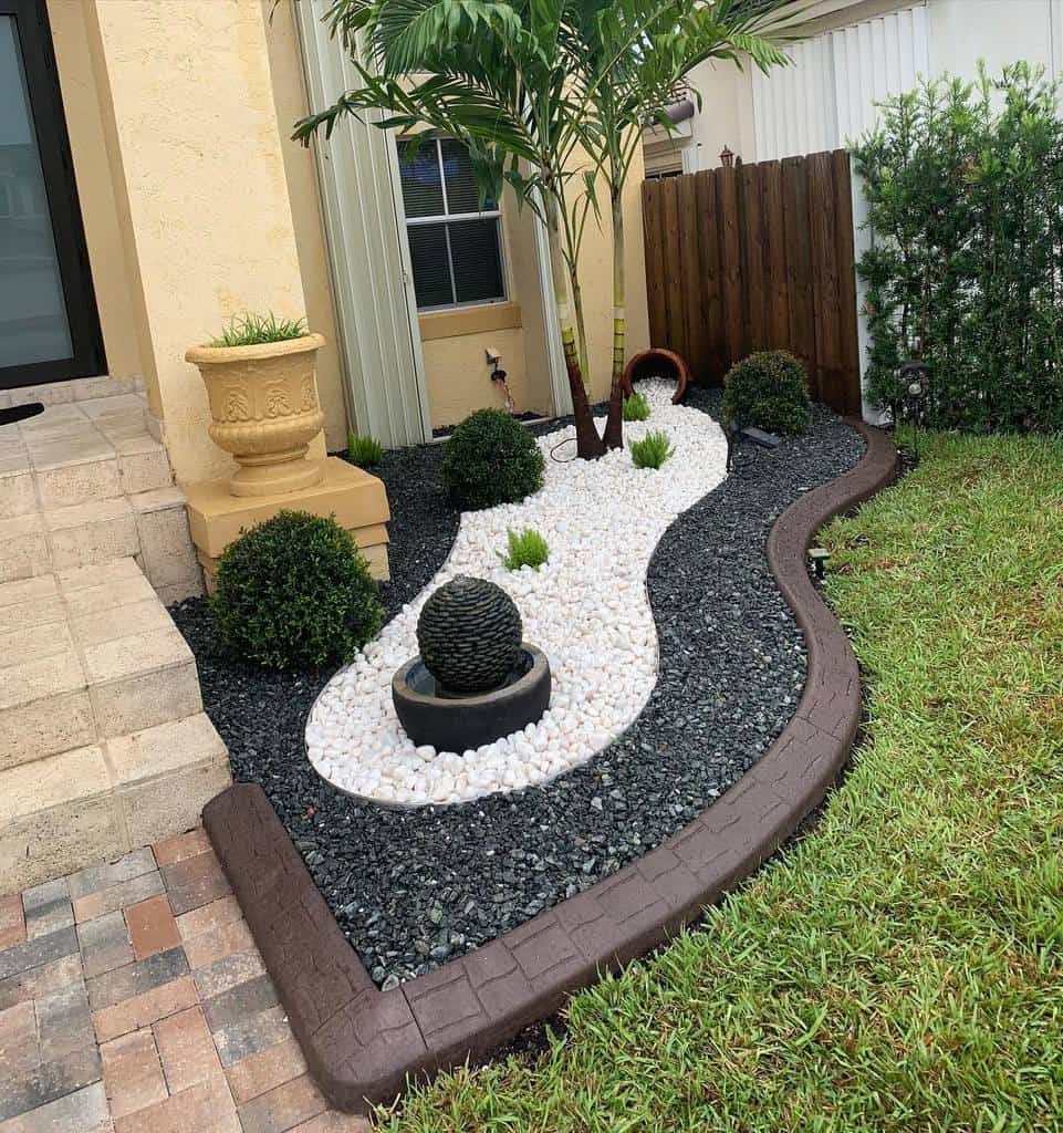 stamped concrete garden edging white and black stones small bushes