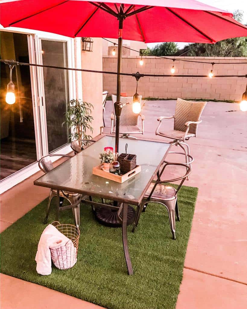 string-lights-patio-lighting-ideasb-creative-w-maritza simple backyard patio with fake grass and large umbrella