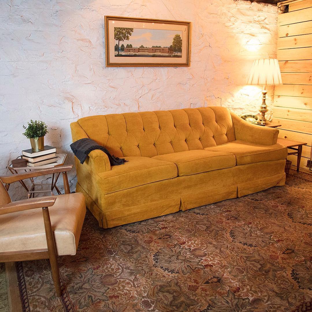 unfinished20basement20apartment20ideas20-joyeverafter Cozy basement room with mustard yellow couch, vintage rug, and soft lighting.