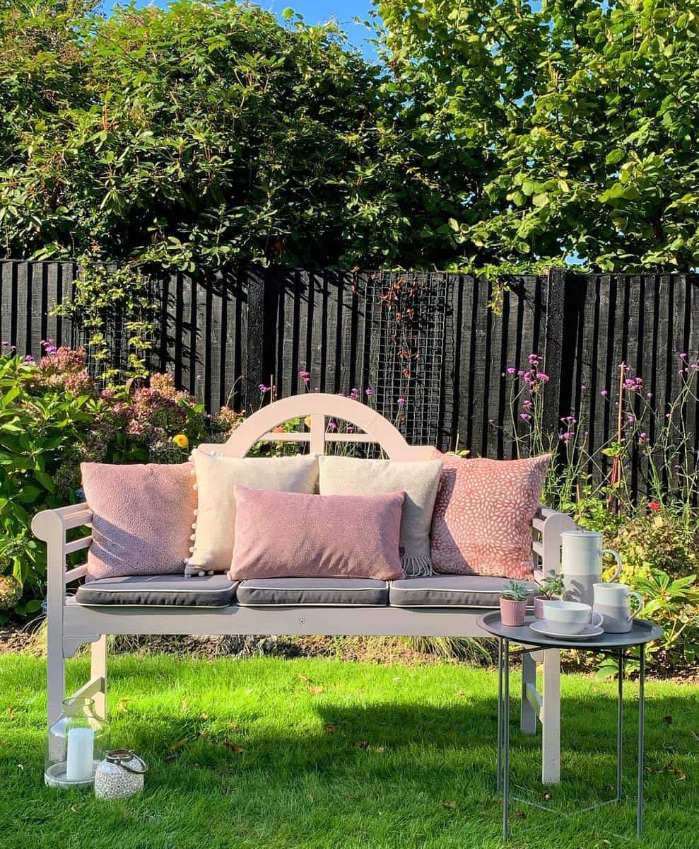 wooden-garden-bench-ideas-jill_house_home pink wood backyard bench small table with tea set pink pillows