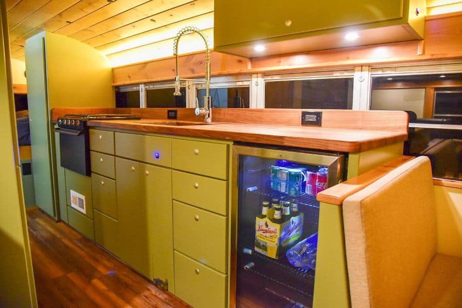 boat kitchen with yellow cabinets and wood countertop