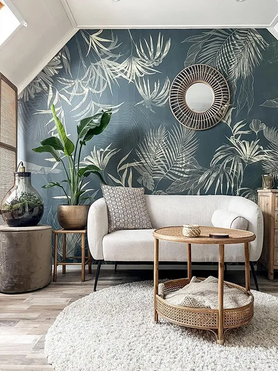 Rattan furniture and deep teal wallpaper with tropical leaves